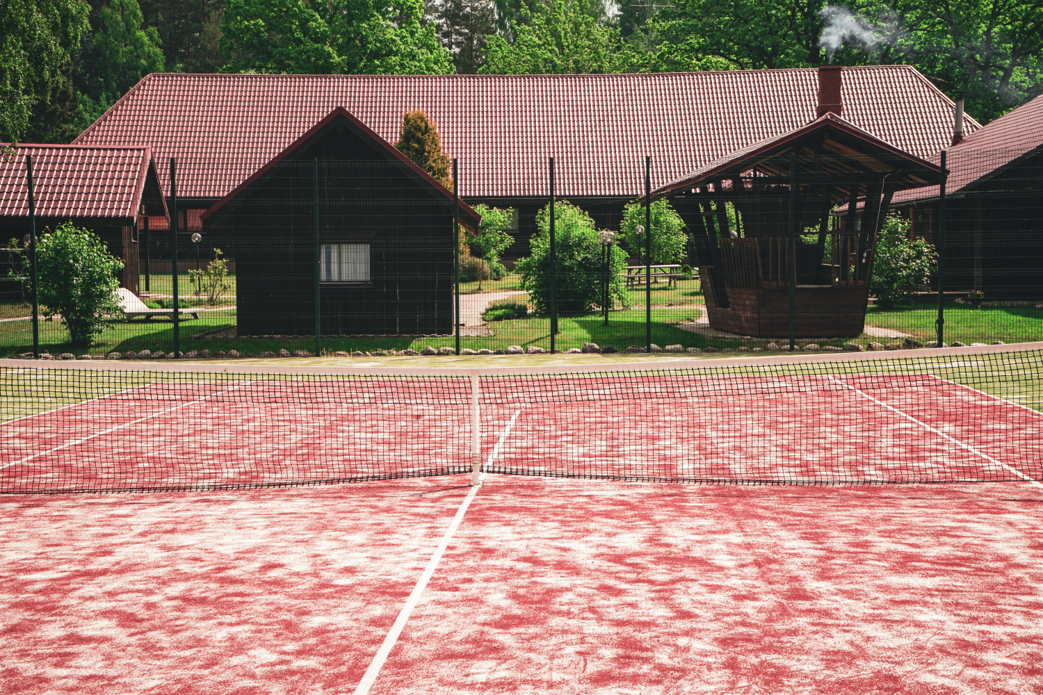 Tennis court framed by pine trees