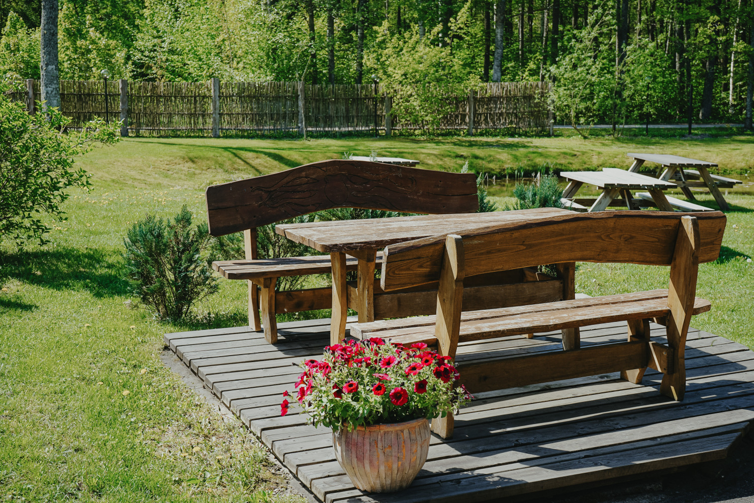 Wooden bench with petunias overlooking the manor pond